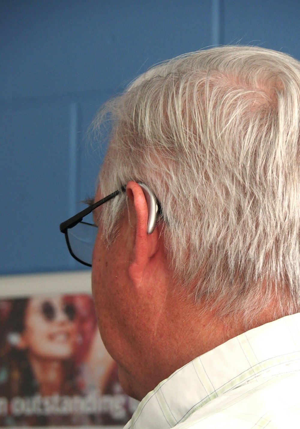 a man with white hair wearing a pair of black glasses