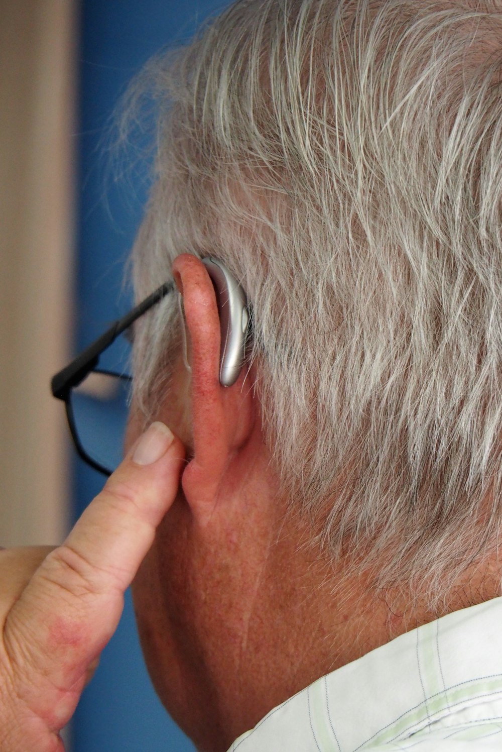 an older man wearing a pair of ear buds