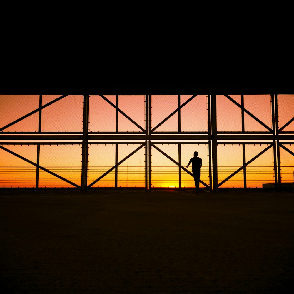 a person standing in front of a window at sunset