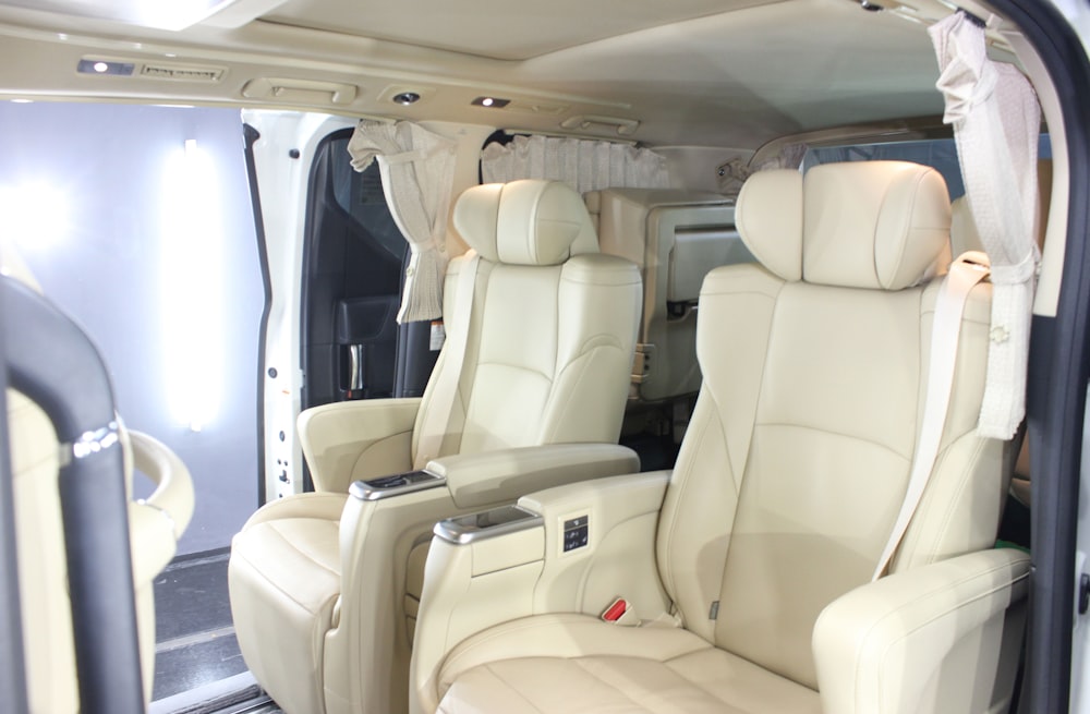 the interior of a vehicle with white leather seats