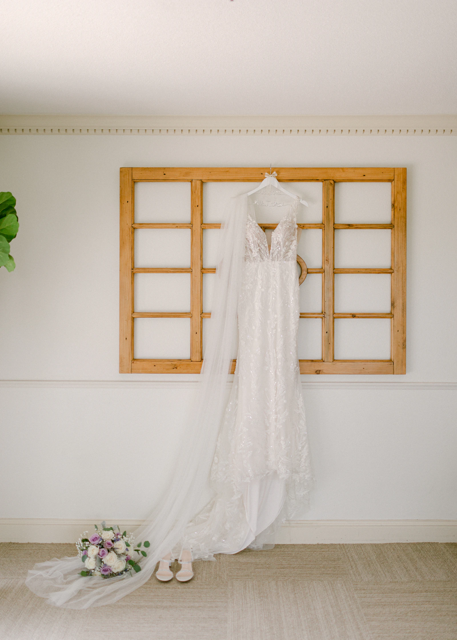 Robe de mariée suspendue à côté d'un bouquet, option seconde main ou location pour un mariage éco-responsable