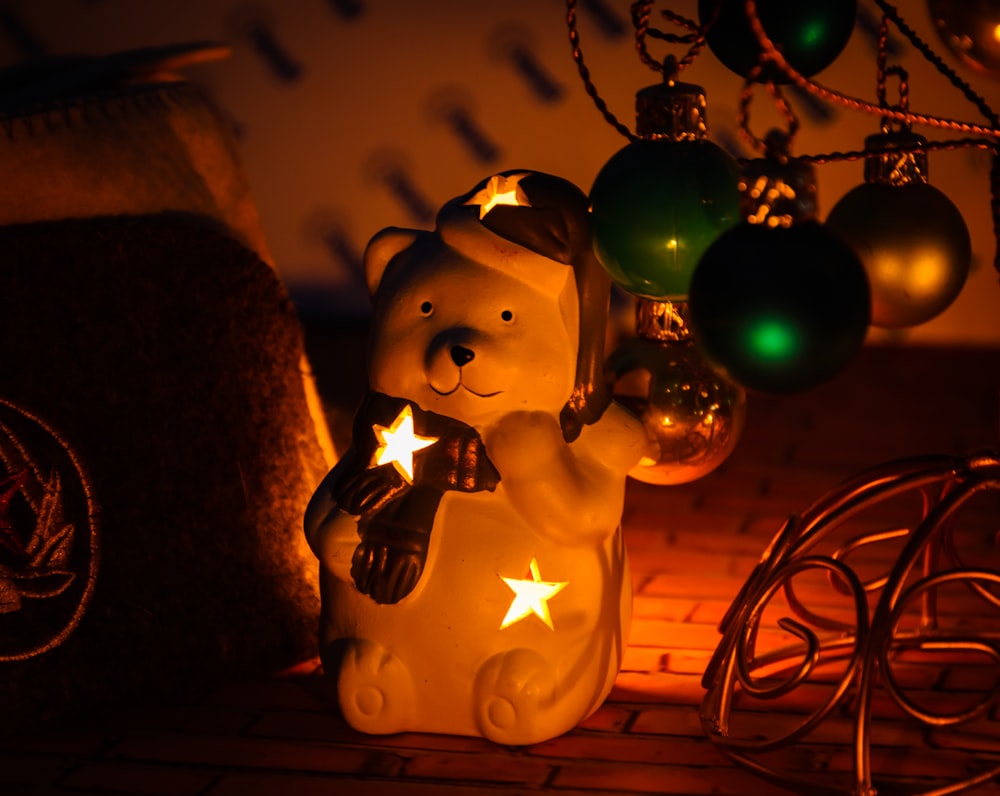 a teddy bear holding a star next to a christmas ornament