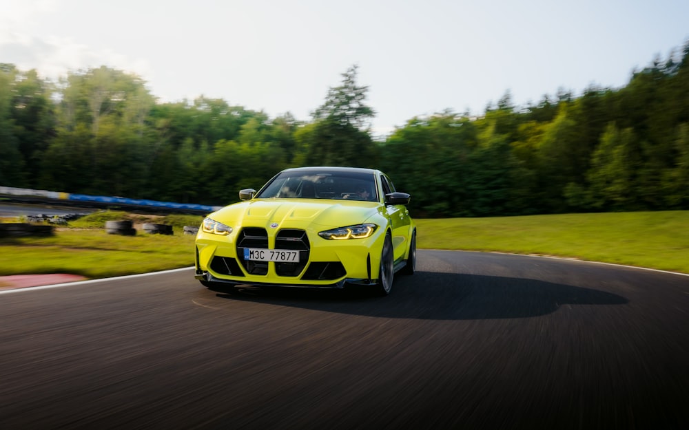 a yellow sports car driving down a winding road