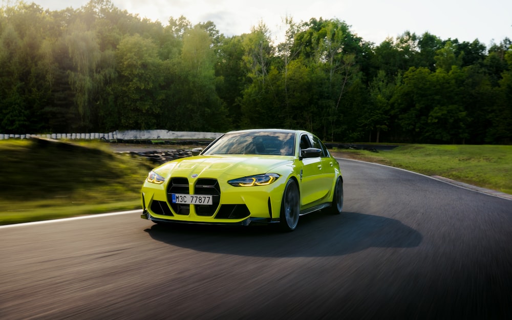 a yellow sports car driving down a road