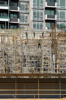 a building under construction with scaffolding and workers
