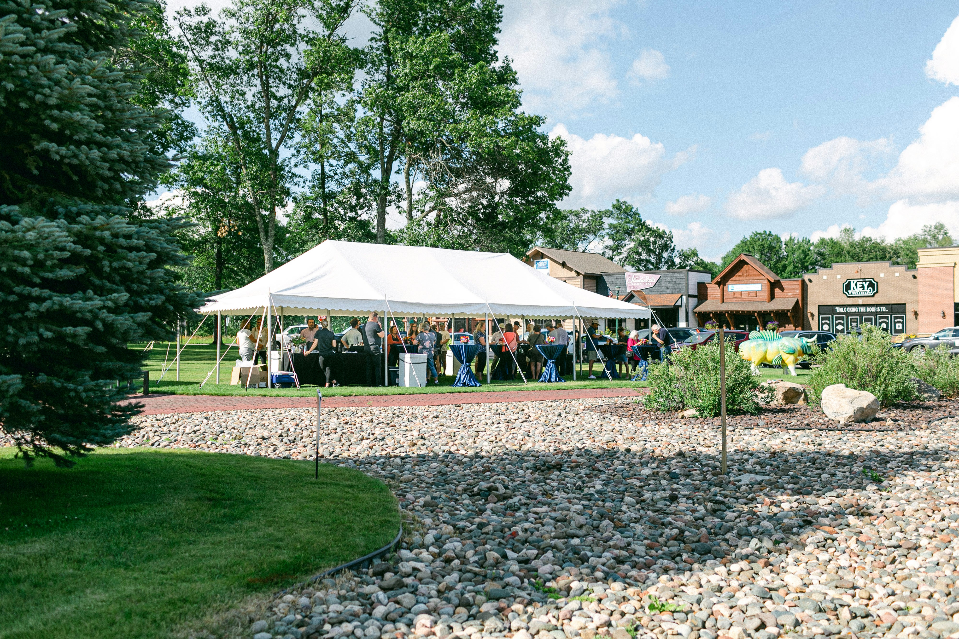 a group of people standing under a white tent