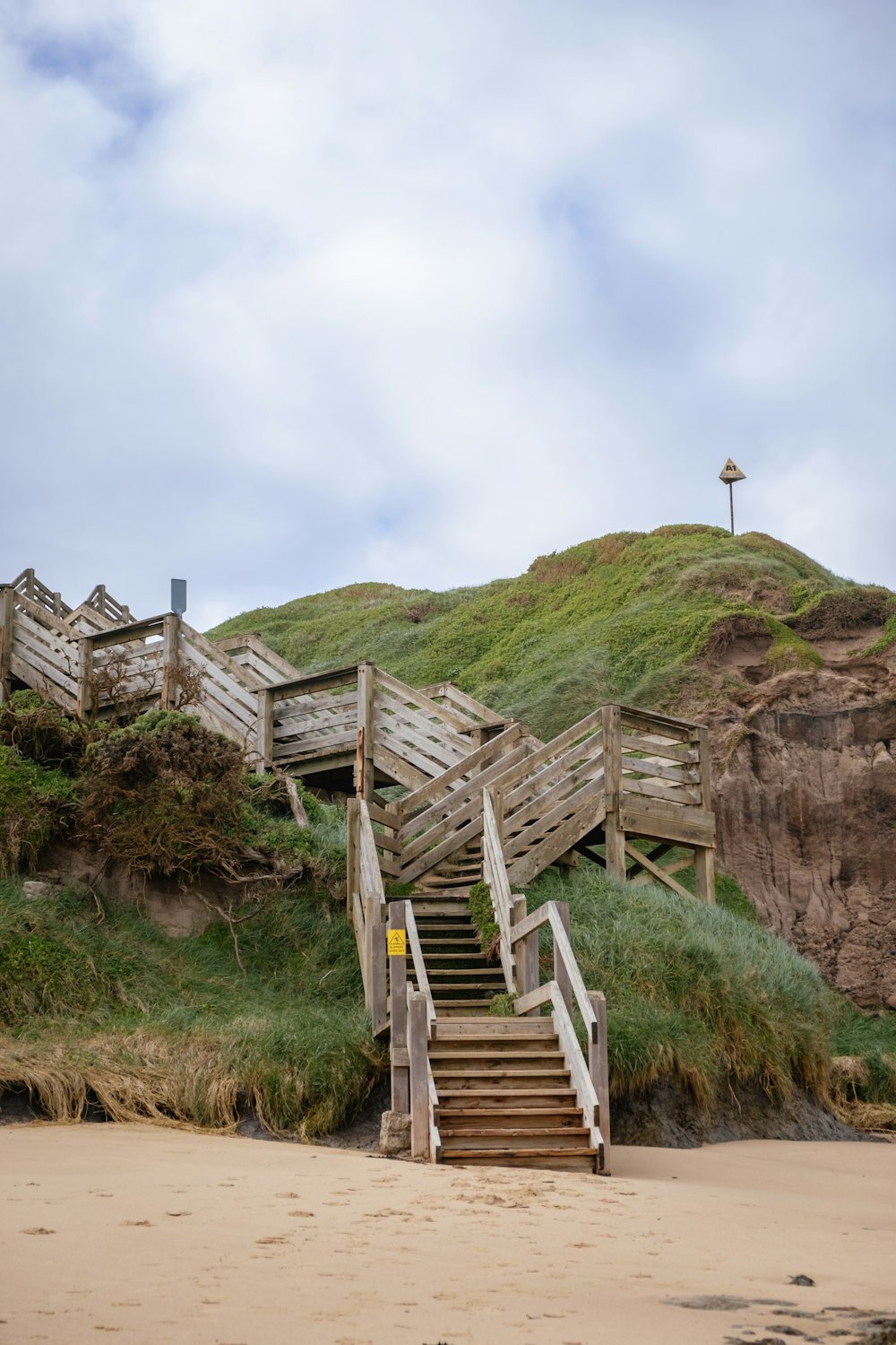 a set of stairs leading up to a sandy beach