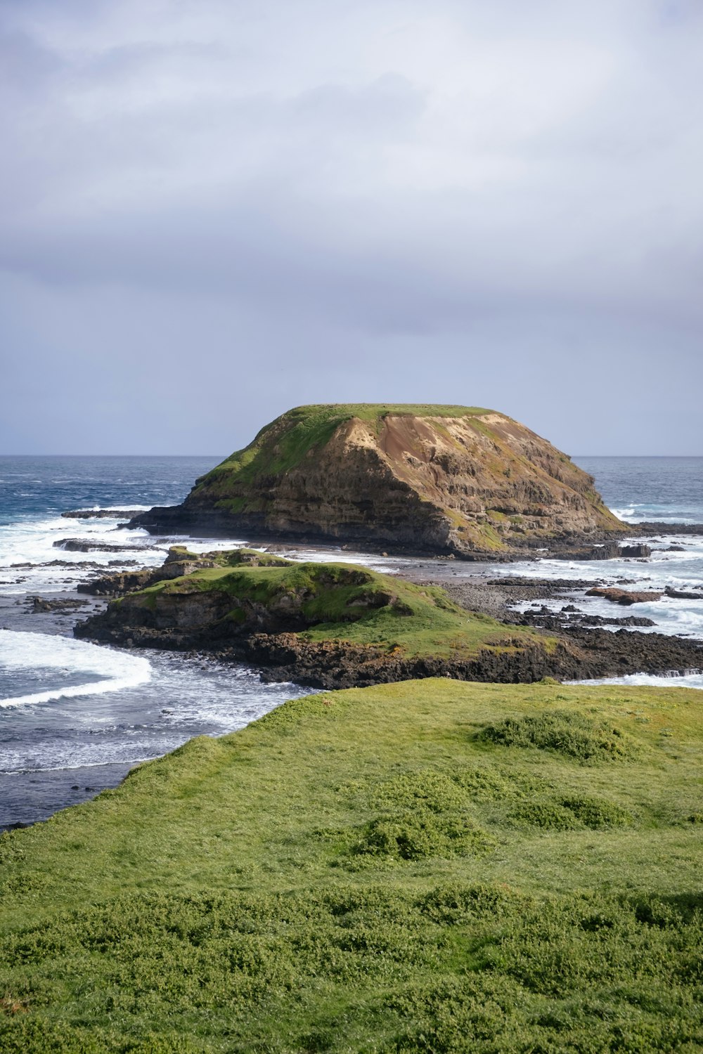 a grassy hill next to a body of water