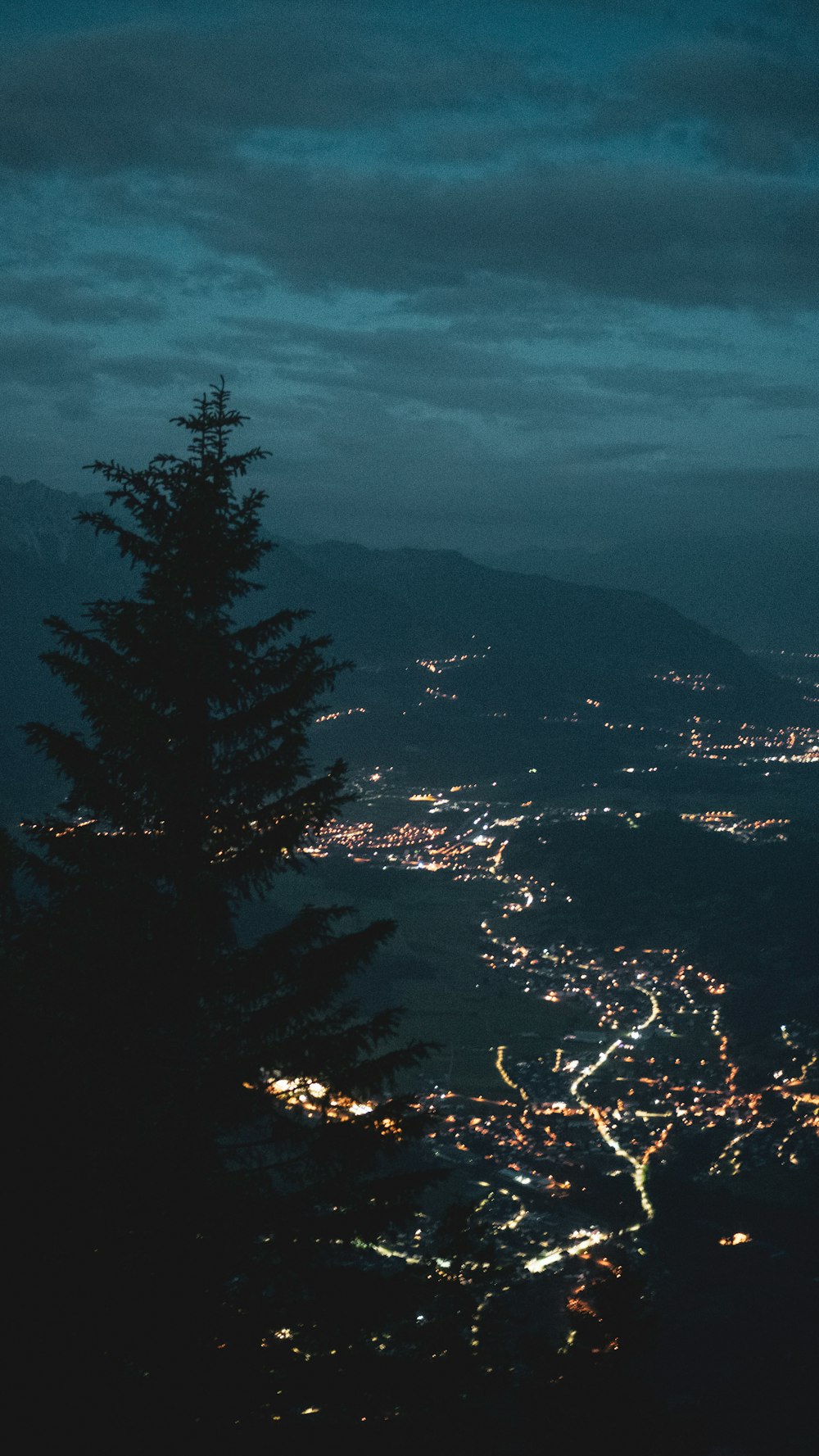 a view of a city from a hill at night