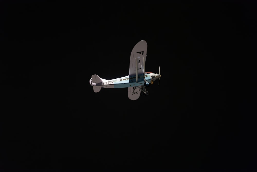 a small airplane flying through a dark sky