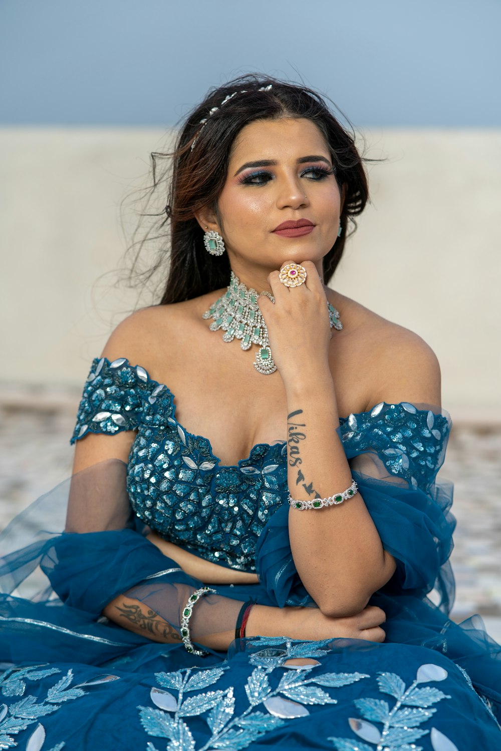 a woman in a blue dress sitting on the ground