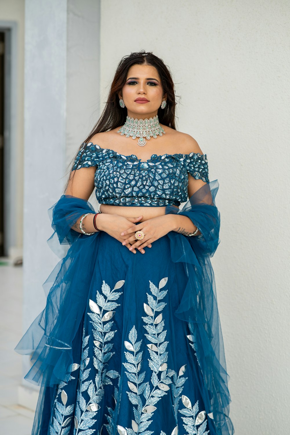 a woman in a blue dress standing in front of a building