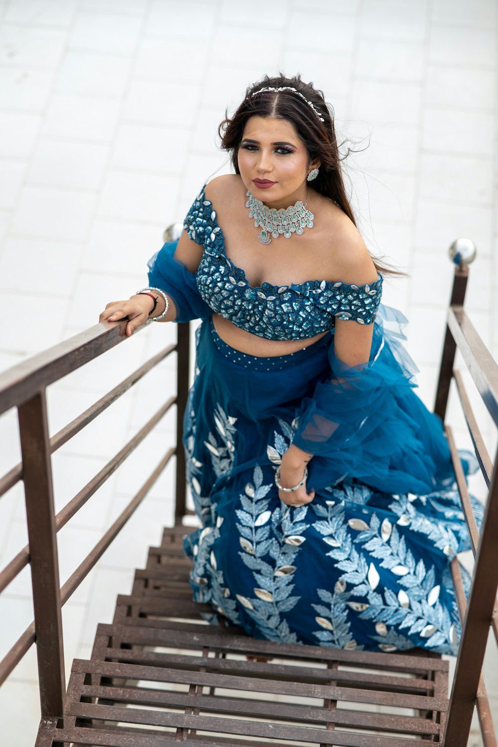 a woman in a blue dress sitting on a wooden bench