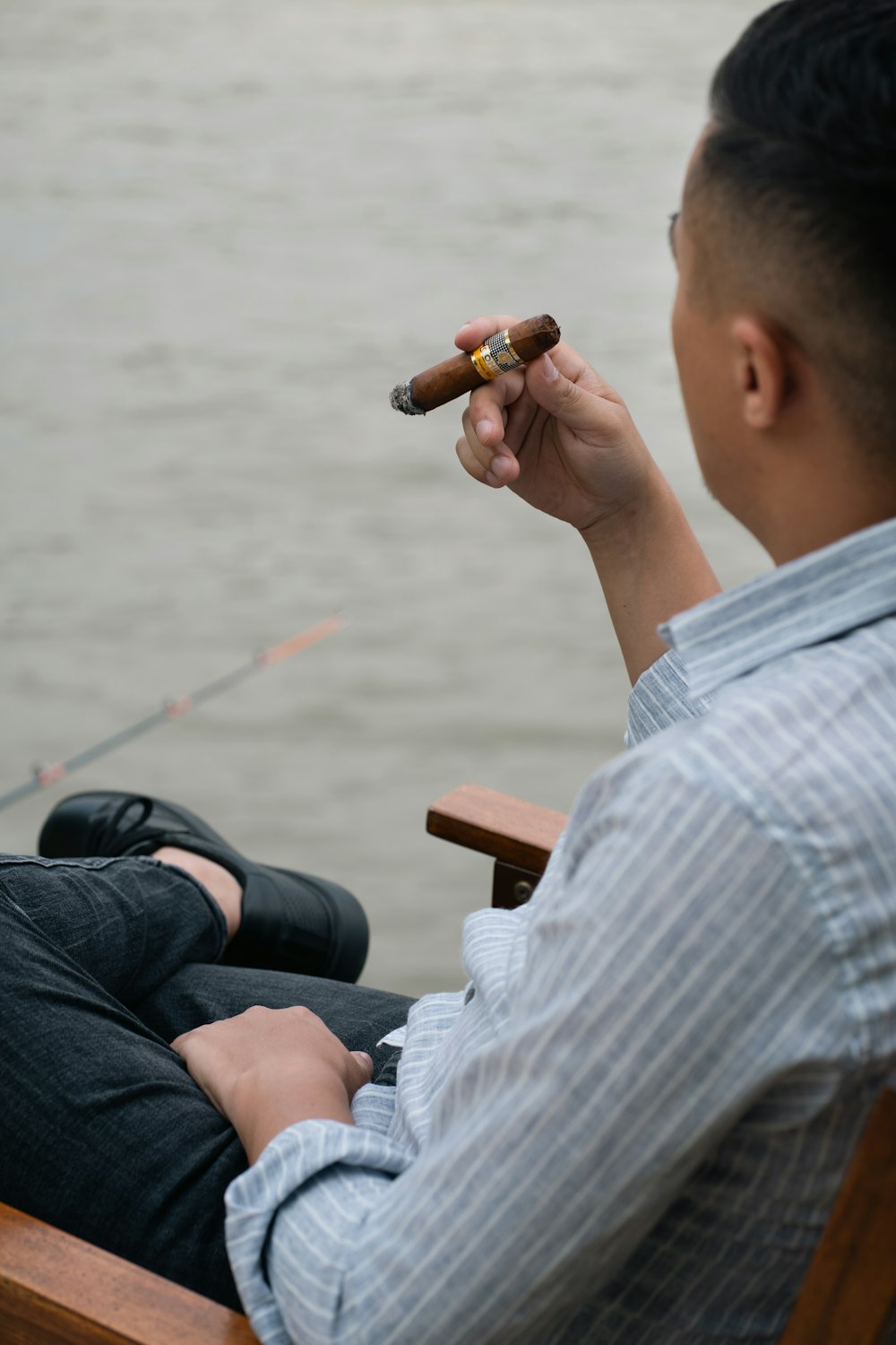 a man sitting in a chair holding a cigar