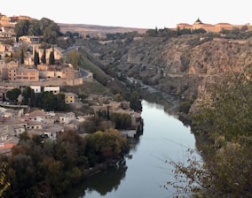 A scenic view of Swat River with lush green hills and a bonfire glowing at dusk.