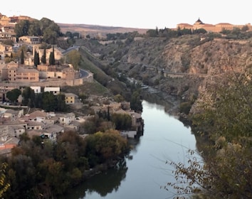 A scenic view of Swat River with lush green hills and a bonfire glowing at dusk.