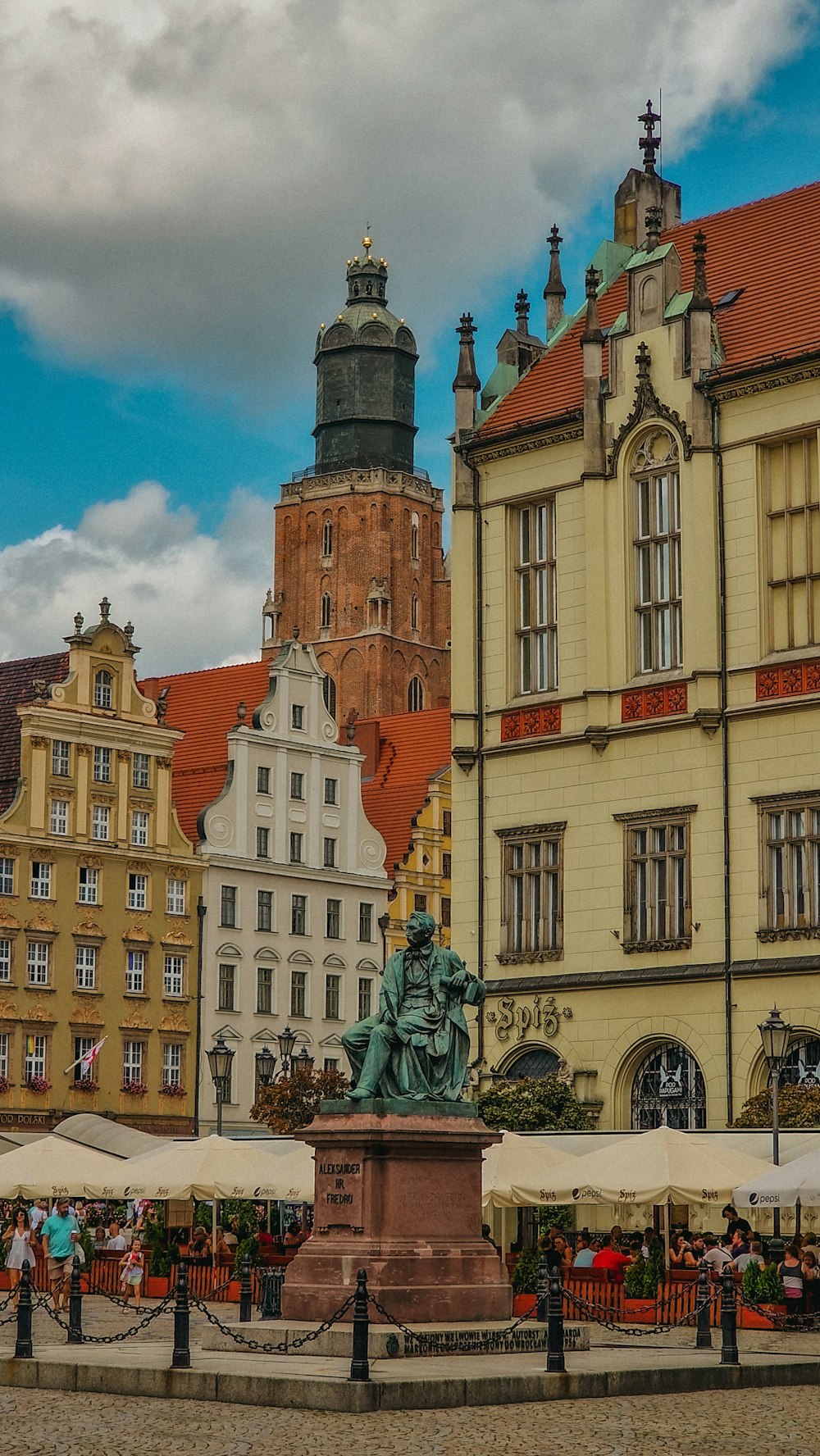 a statue in front of a building with a clock tower in the background