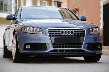 A sleek car ready for rental with a backdrop of bustling city streets in India.