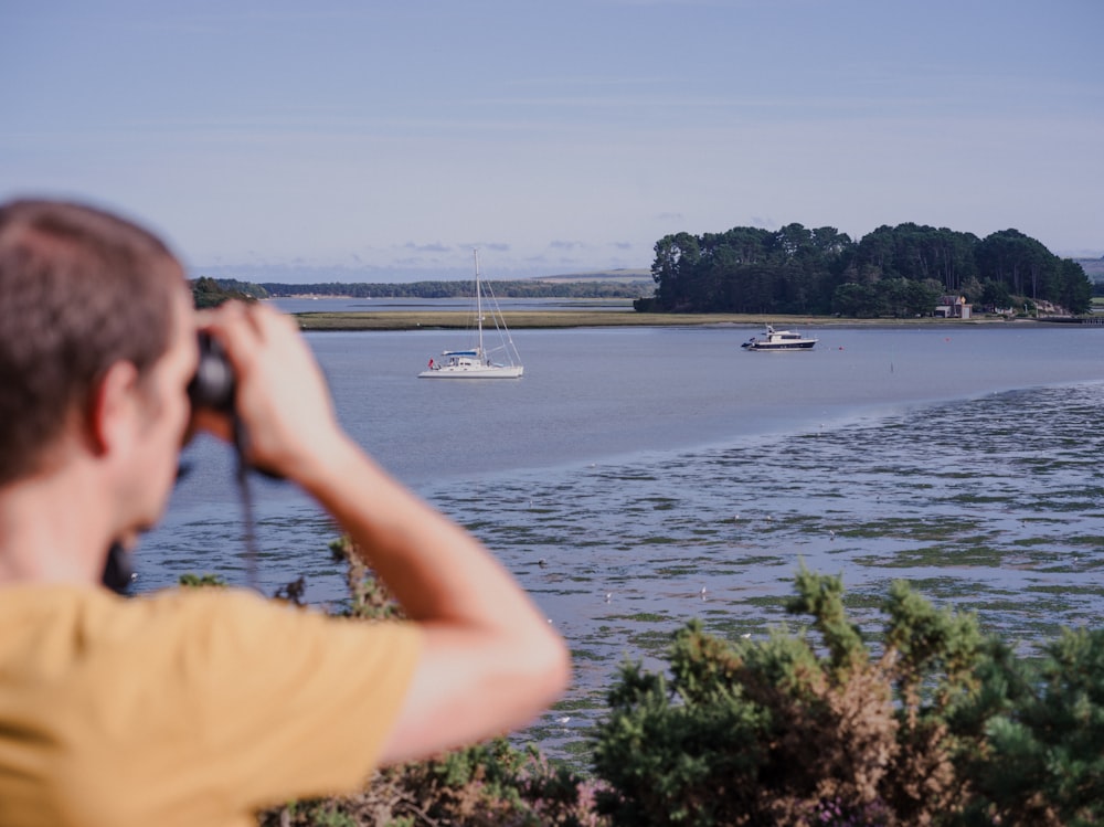 a man taking a picture of a boat in the water