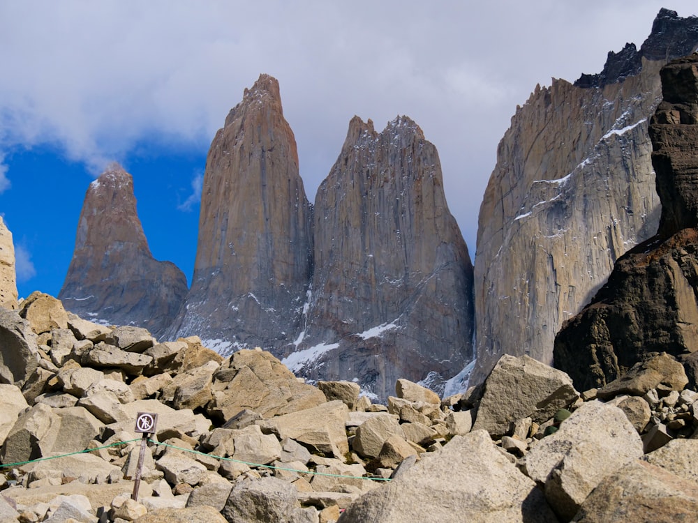 a mountain range with rocks and a sign in the foreground