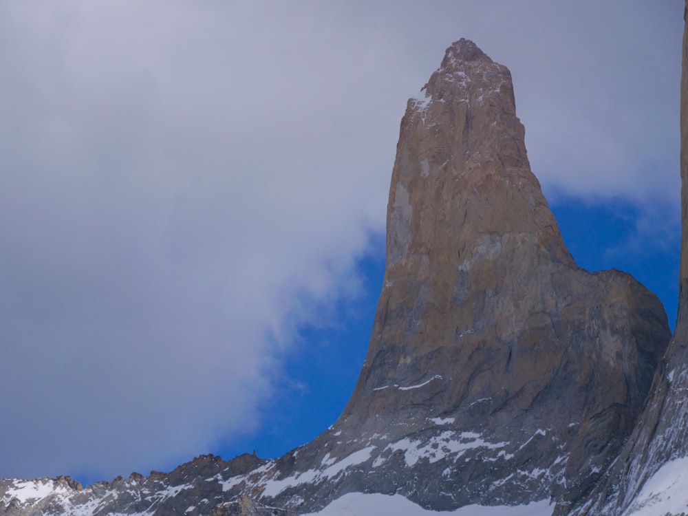 a tall mountain towering over a snow covered mountain