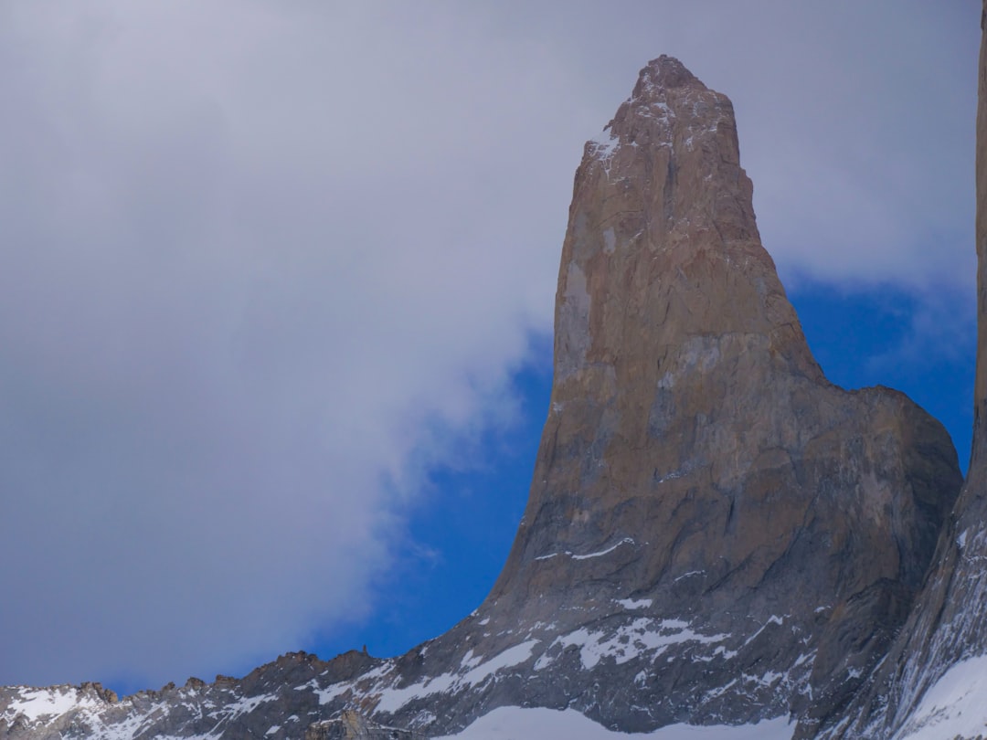 a tall mountain towering over a snow covered mountain,