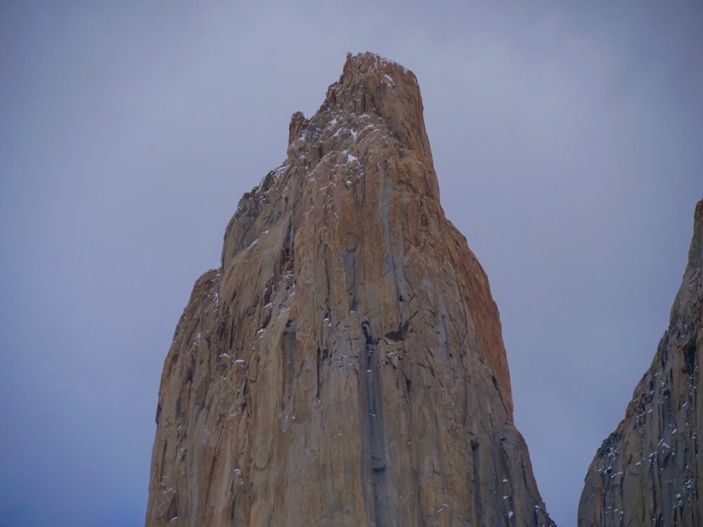 a tall rock formation with a sky background