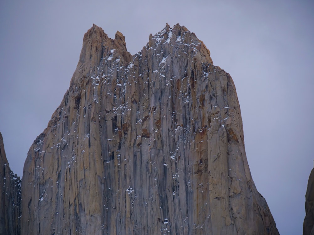 a tall rock formation with snow on it