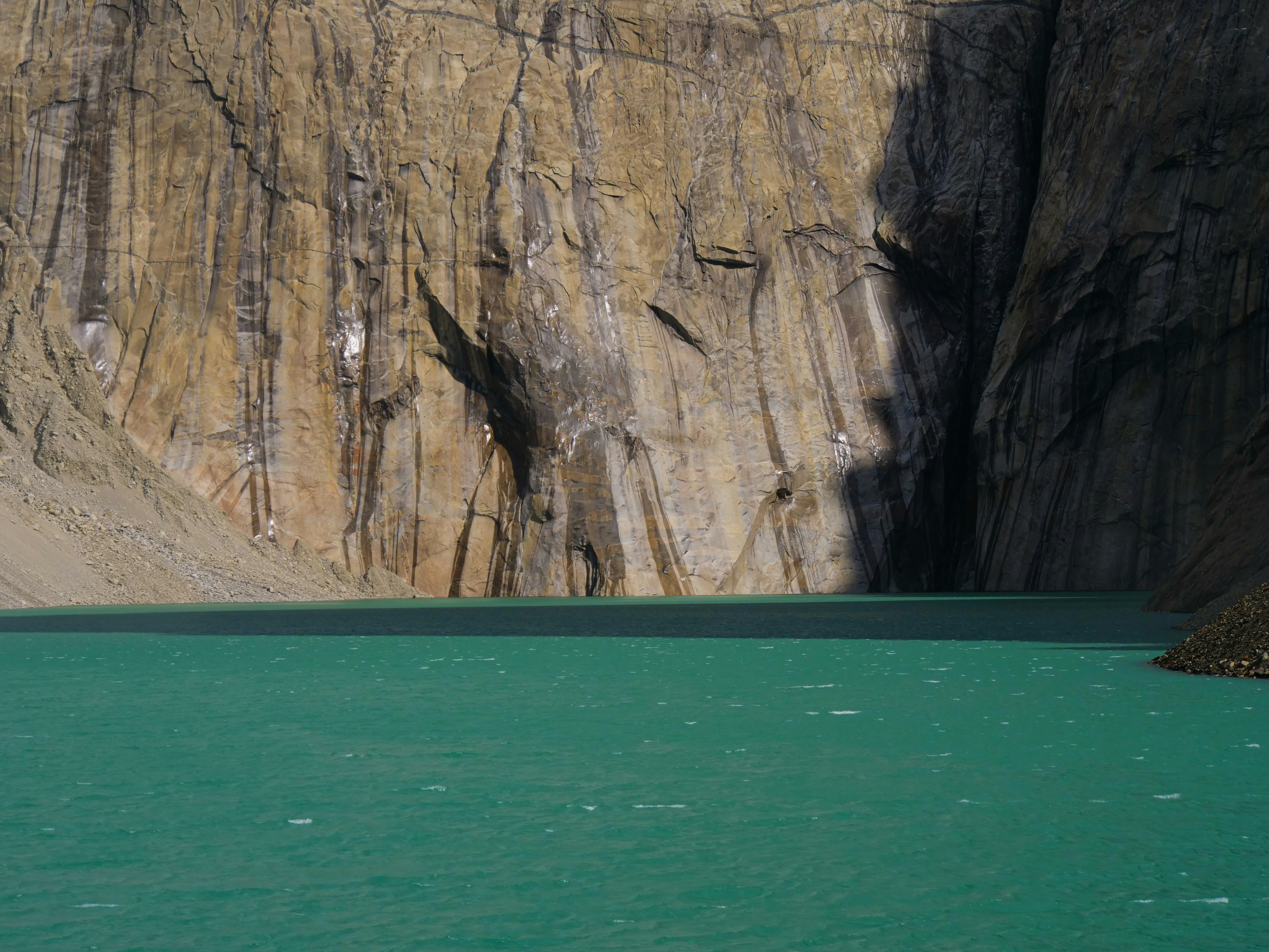 a body of water with a cliff in the background, 