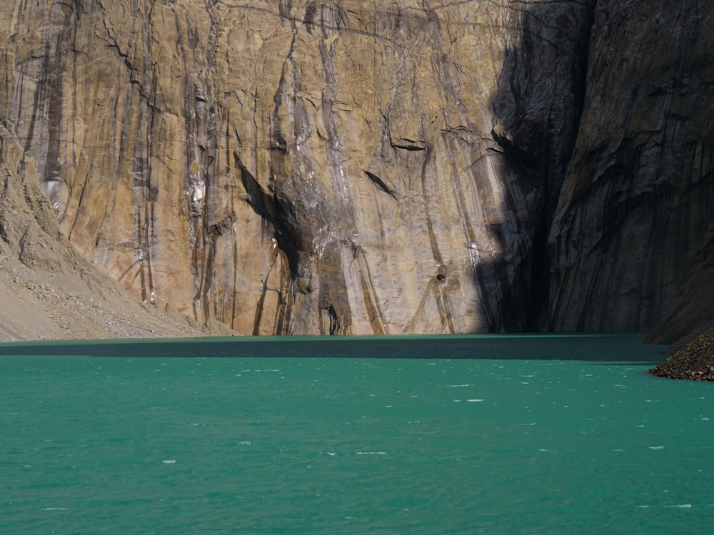 a body of water with a cliff in the background