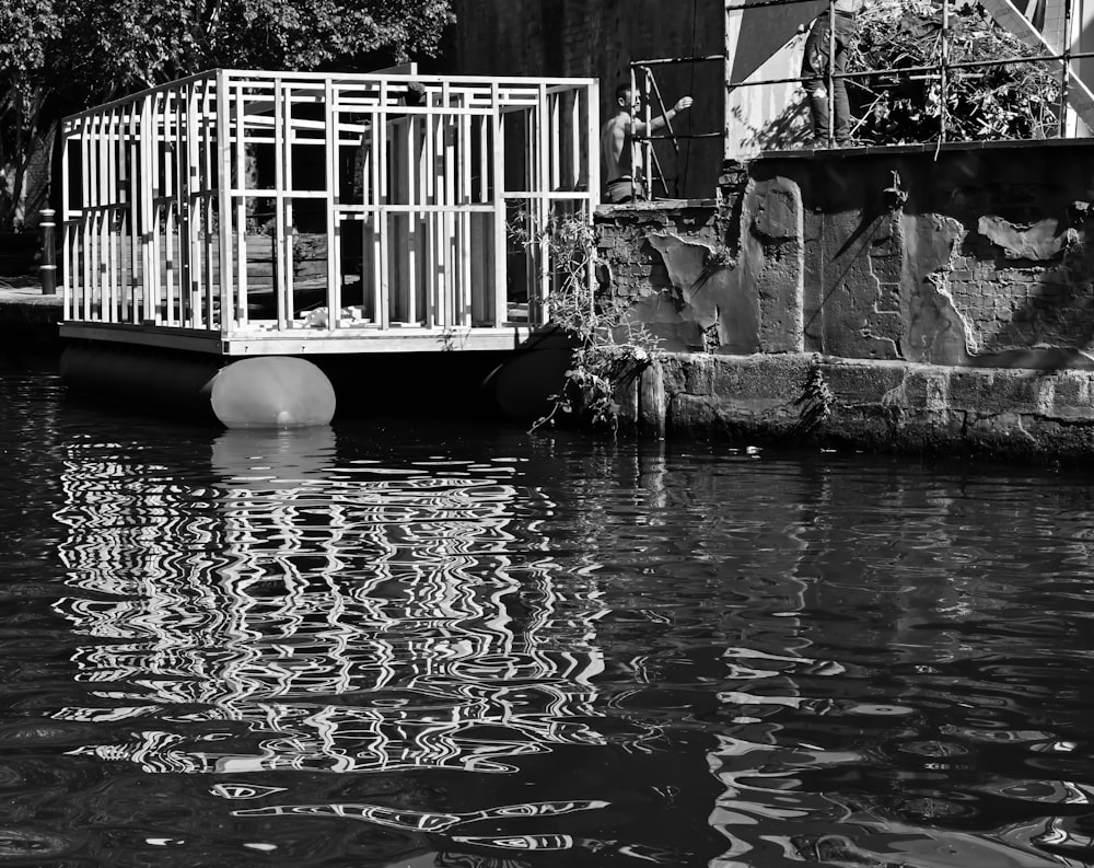 a bird cage sitting on top of a body of water