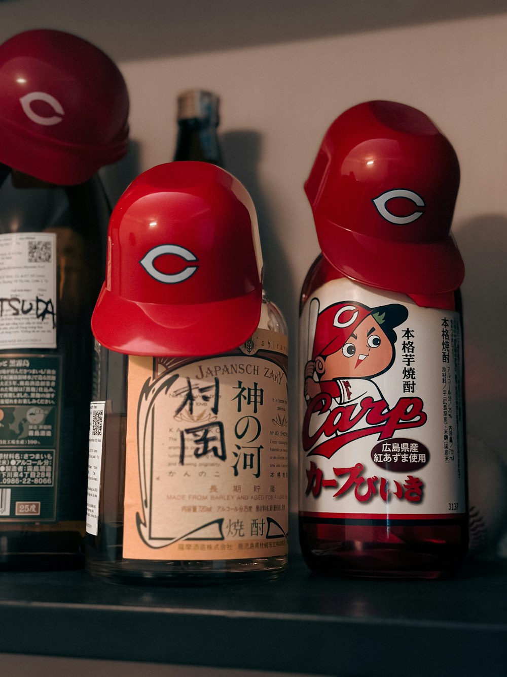 a shelf filled with bottles of liquor and baseball caps