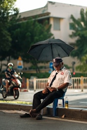 a man sitting on a blue chair holding an umbrella
