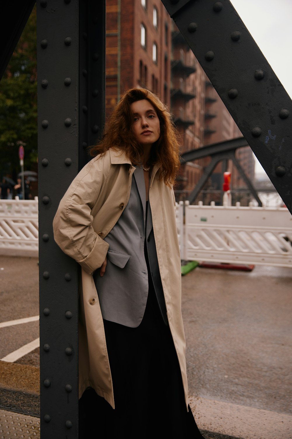 a woman leaning against a metal structure in a city