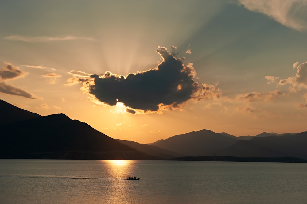 a boat in a body of water with mountains in the background