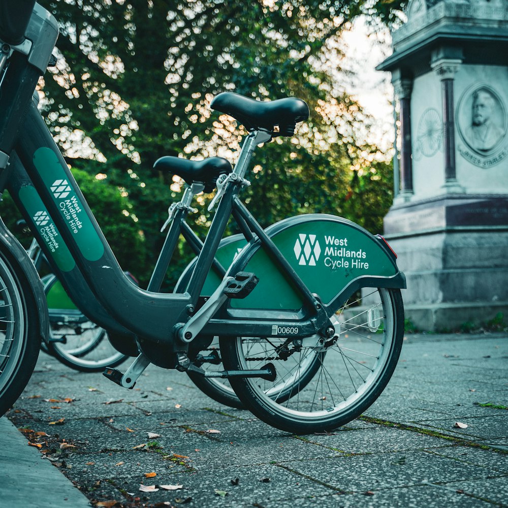 a green bike parked next to a monument