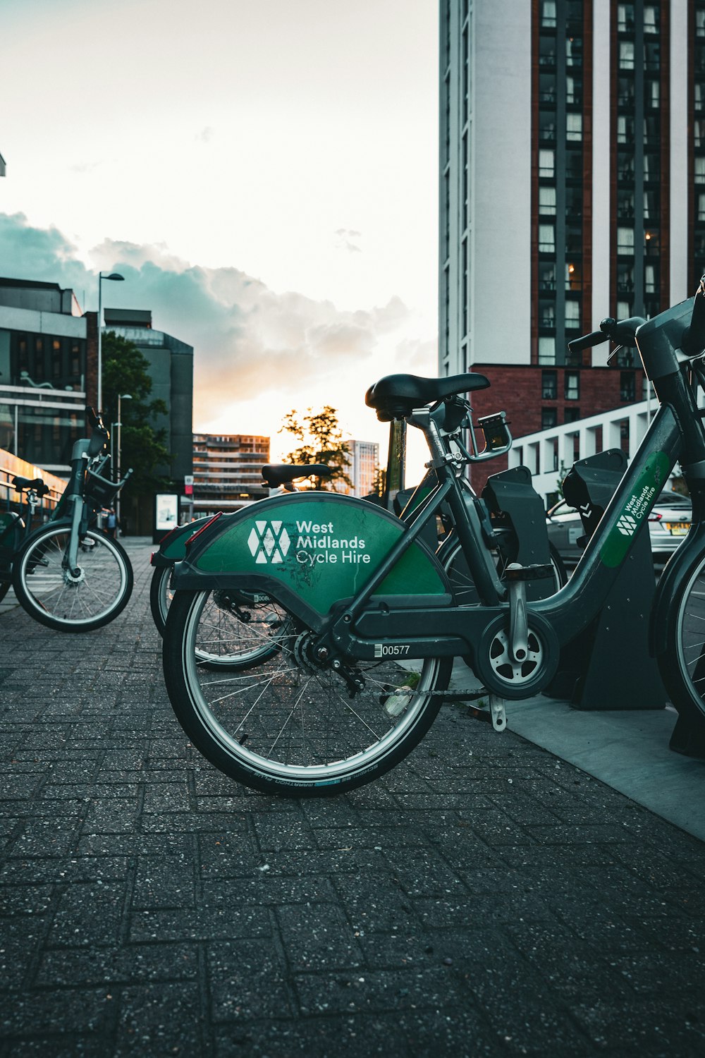 two bikes parked next to each other on a sidewalk