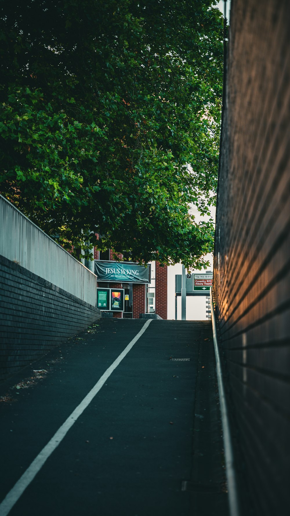 a street with a brick wall and trees