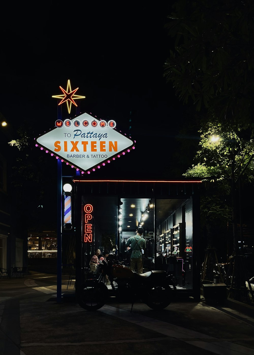 a motorcycle parked in front of a neon sign