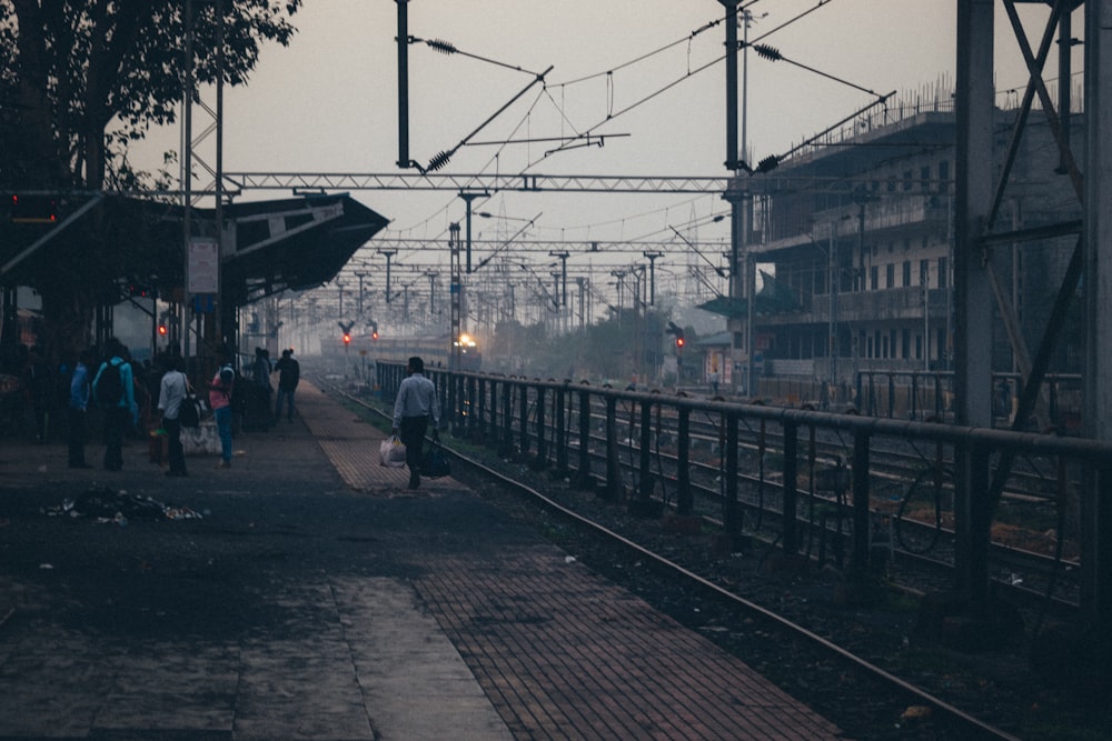 a group of people walking down a train track