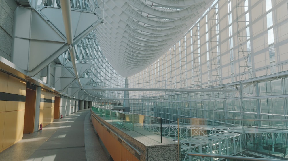 a walkway inside of a large building with lots of windows