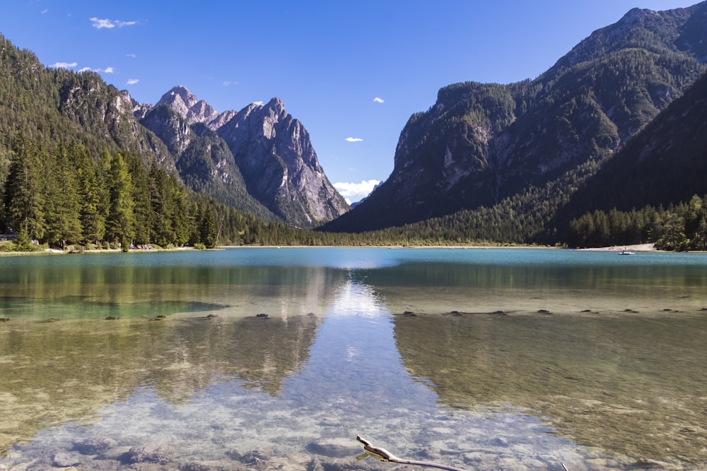 a lake surrounded by mountains and a forest