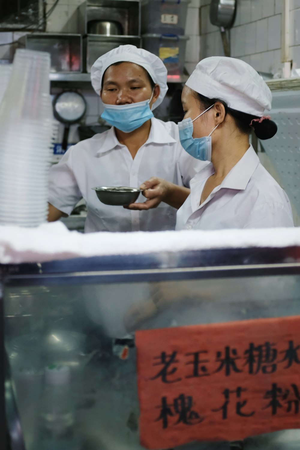 a couple of women standing next to each other in a kitchen