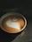 A beautifully crafted coffee cup with latte art beside a Crema Bot.