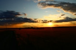 A tranquil sunset sky with pastel colors over a quiet field.