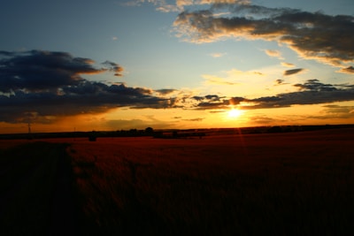 A tranquil sunset sky with pastel colors over a quiet field.