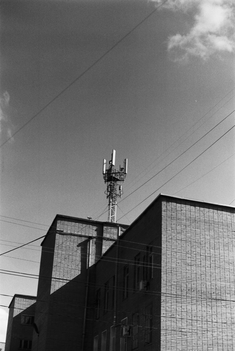 a black and white photo of a building and a cell phone tower