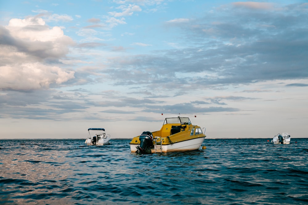 a yellow and white boat floating on top of a body of water