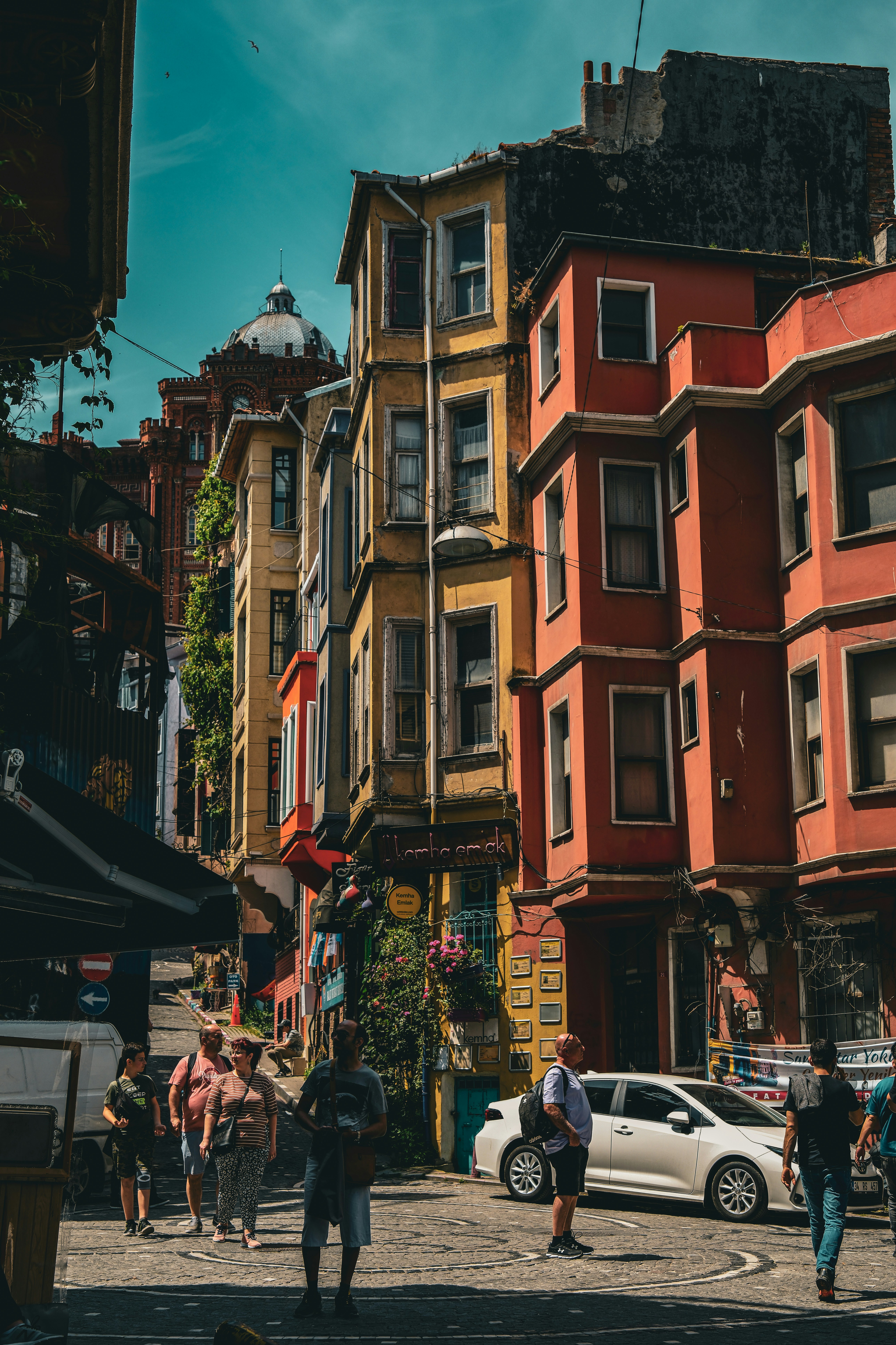 a group of people walking down a street next to tall buildings