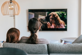 a couple of women sitting on top of a couch